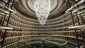 A modern interior with a central spiral staircase, surrounded by rows of wine racks. - New World Millennium Hong Kong Hotel (Kowloon)