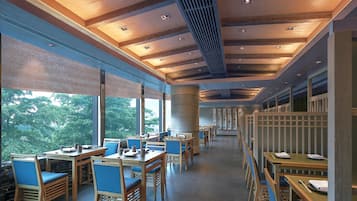 A spacious restaurant with high ceilings, large windows, and wooden furniture.