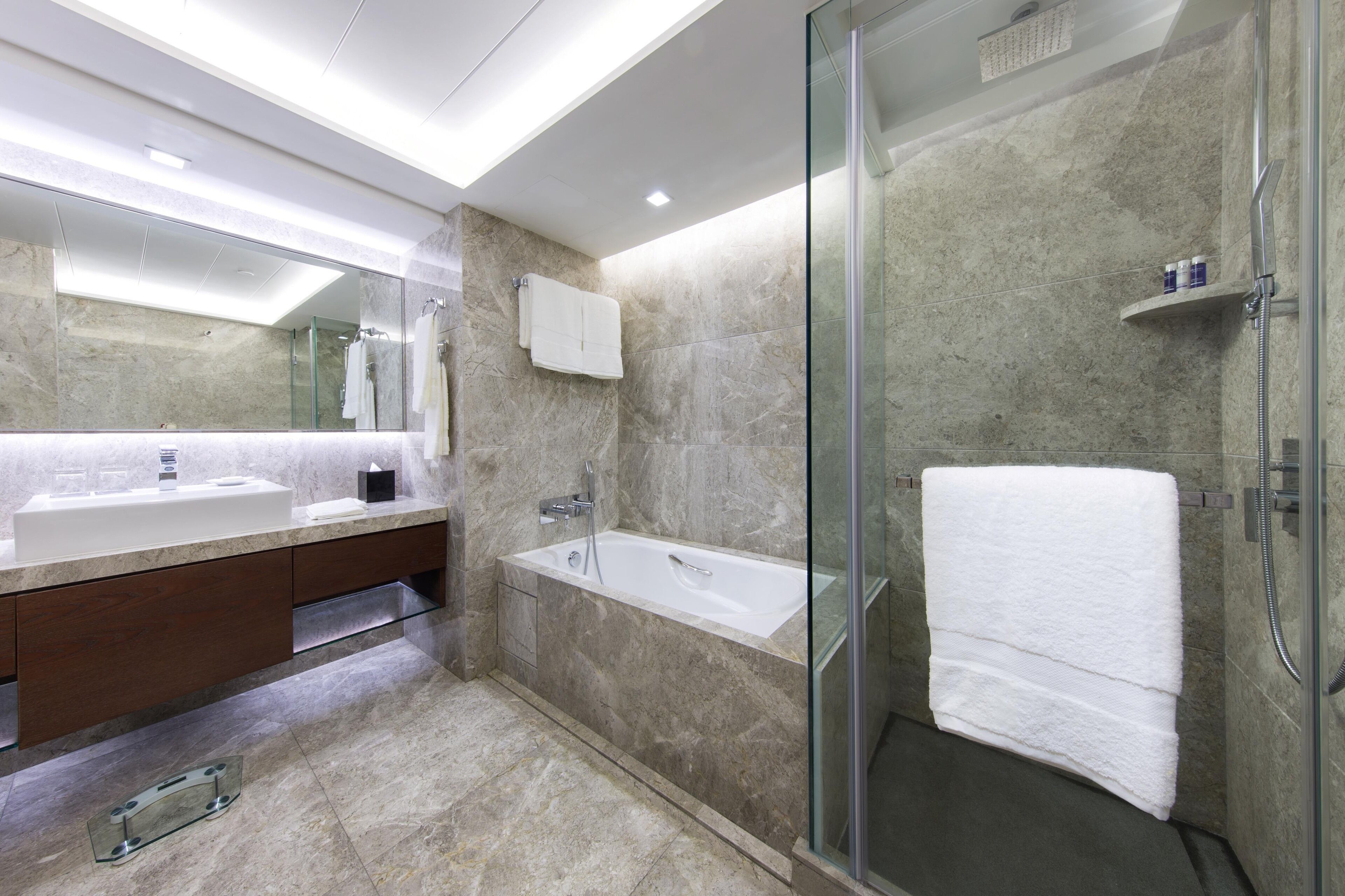 A modern bathroom with a glass-enclosed shower, a large mirror, and a dual sink vanity.