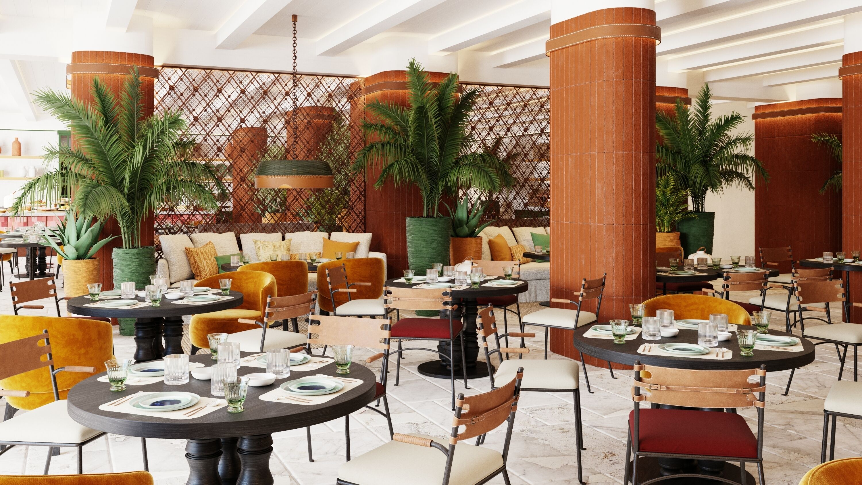 Un amplio comedor interior con varias mesas y sillas redondas, rodeado de grandes macetas con plantas y una pared decorativa.