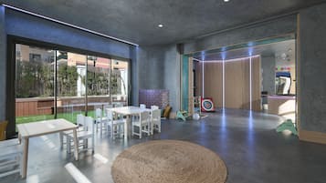 Un interior moderno con un tapete redondo tejido, muebles blancos y un ventanal con vistas a un jardín.