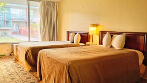 A hotel room with two beds, a window with curtains, a lamp, and a view of the outside. - GLH Hotel (Tucson)