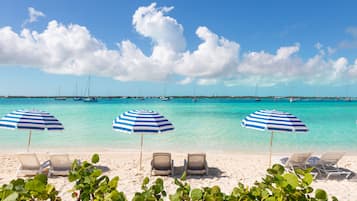On the beach, white sand, sun loungers, beach umbrellas