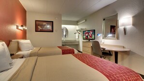 A hotel room with two beds, a desk, a chair, a television, and a mirror. - Red Roof Inn St Louis - Westport/ Maryland Heights (Maryland Heights)