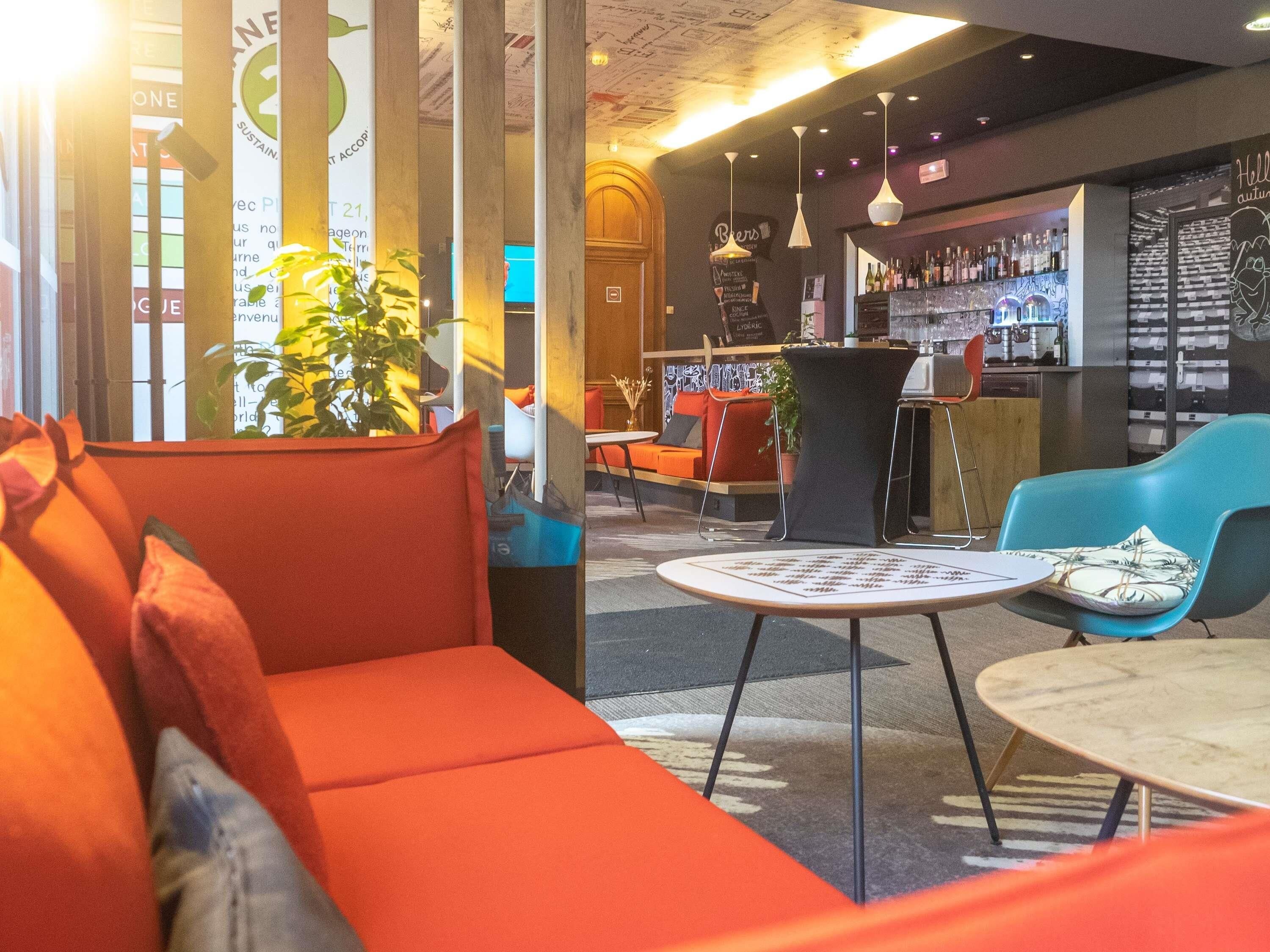 A modern interior with seating areas, a bar, and a visible menu board.