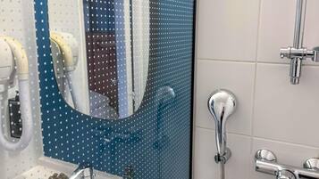 A bathroom with a shower, a sink, and a mirror.