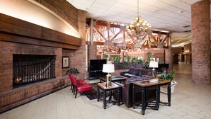 A spacious lobby with a fireplace, leather sofas, and a chandelier. - Red Lion Hotel & Conference Center St. George, UT (St. George)
