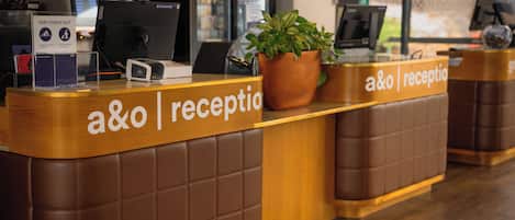 A reception desk with a sign reading 'a&o reception' and a 'FAST CHECK-OUT' sign.