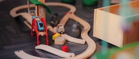 Un conjunto de trenes de juguete de madera sobre un suelo de madera oscura.