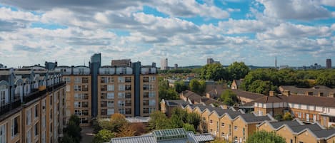 A residential area with terraced houses, a modern building, and a clear sky.