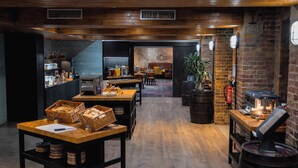 A cozy restaurant with wooden floors, brick walls, and a bar area with a coffee machine.