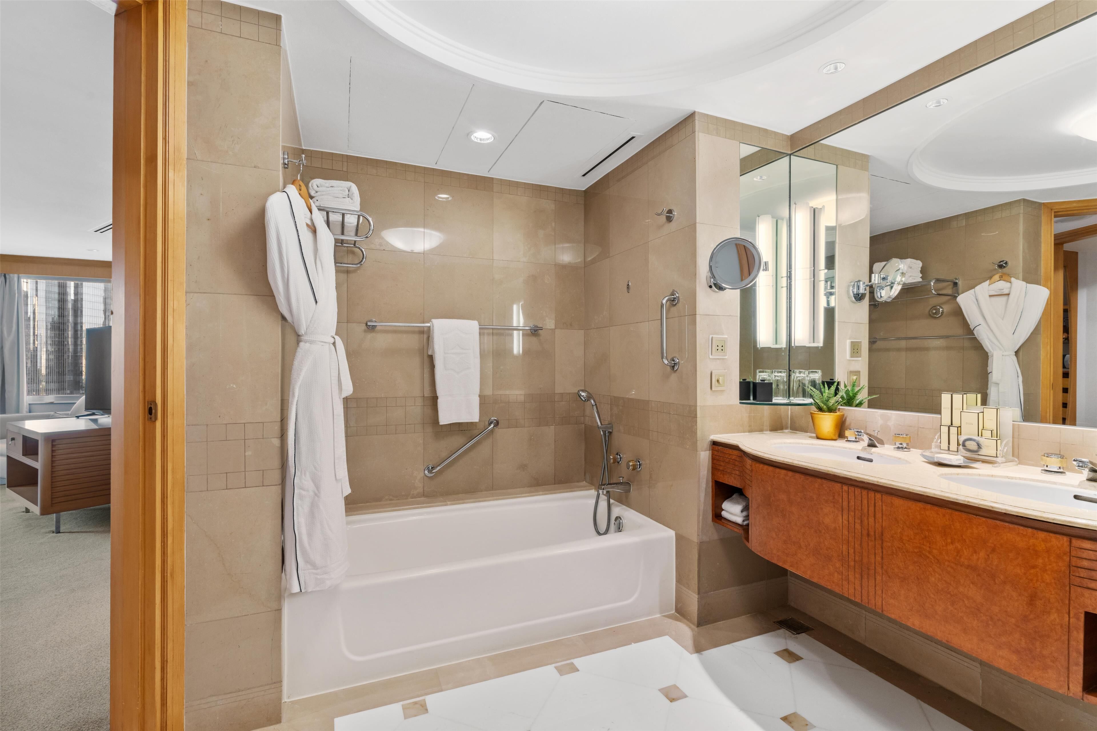 deluxe suite | bathroom | separate bathtub and shower, designer toiletries, hair dryer, bathrobes