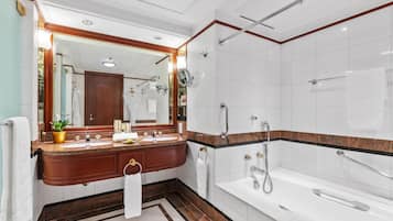 A modern bathroom with a marble vanity, a large mirror, a bathtub, and a shower area.