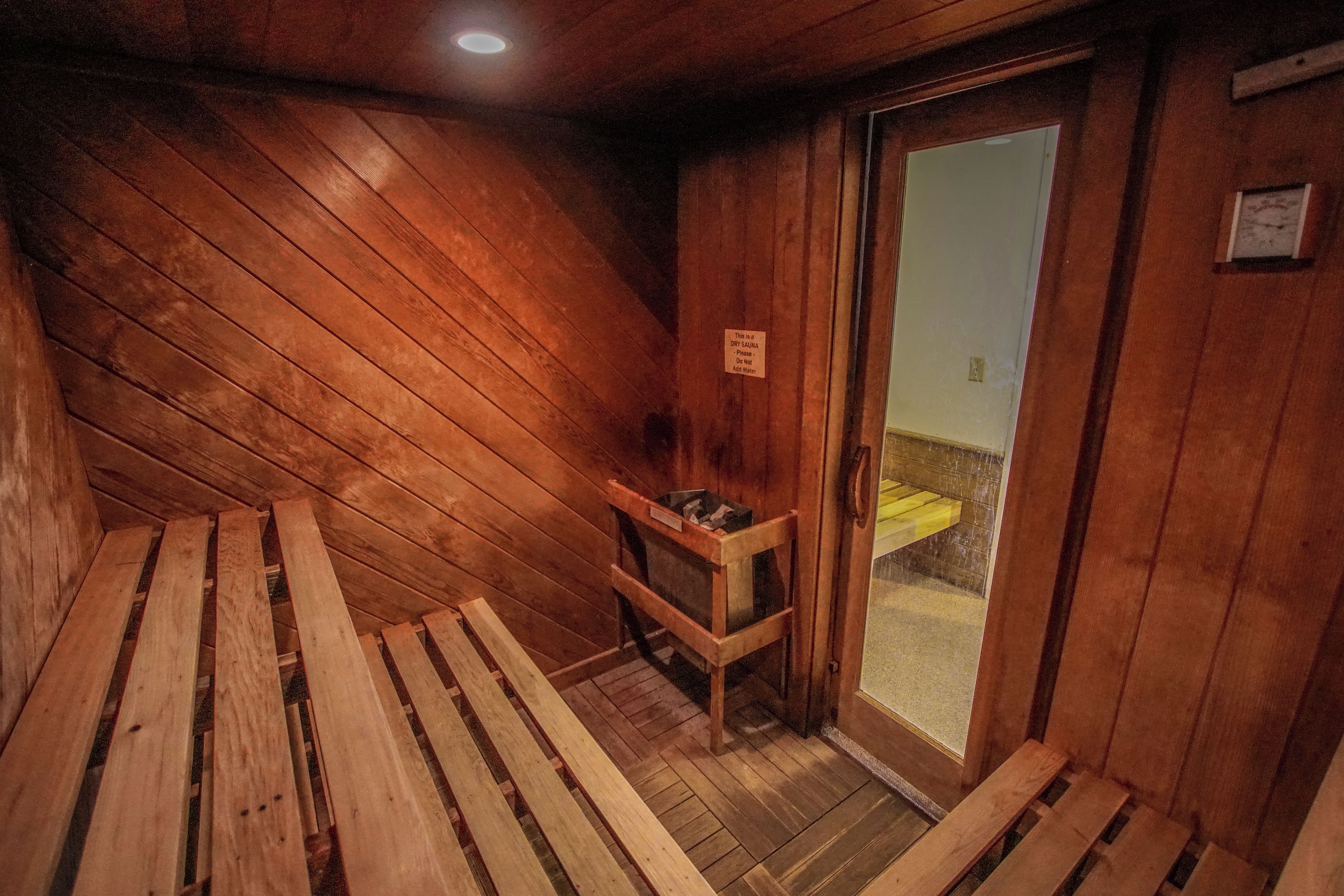 A dry sauna room with wooden benches and a bench with towels.