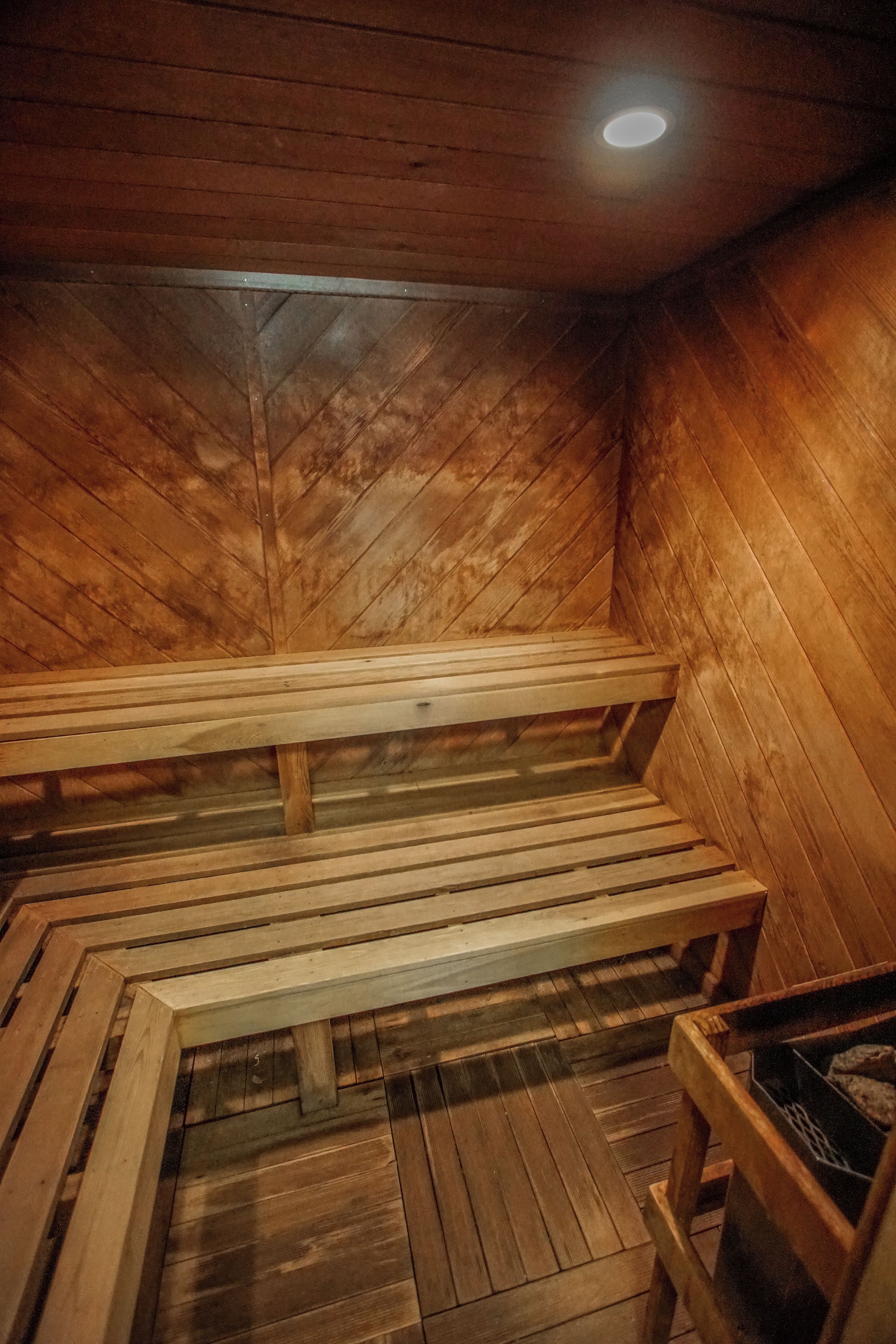 Una sauna con bancos de madera y techo inclinado.