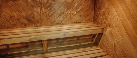 Una sauna con bancos de madera y techo inclinado.