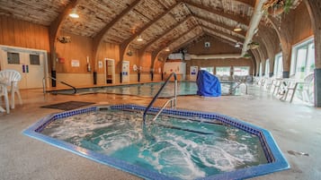 Une piscine intérieure avec un plafond en bois et un sol carrelé.