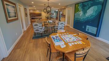 A dining area with a wooden table set for two, surrounded by patterned chairs.