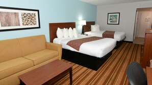 A hotel room with two beds, a sofa, a desk, and a framed picture on the wall. - Rock Island Inn & Suites Marshalltown (Marshalltown)