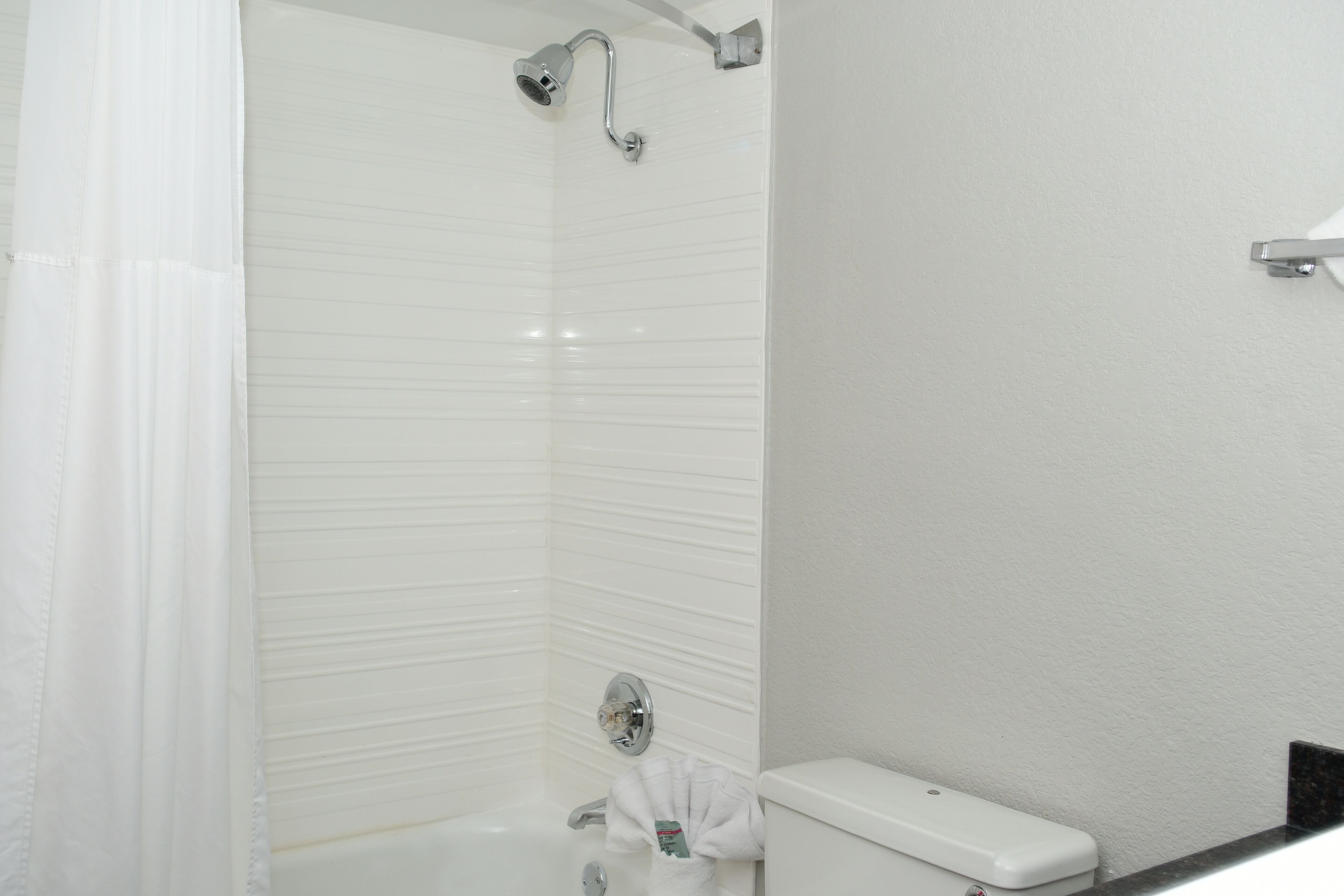 Een badkamer met douche, toilet en handdoekrek.