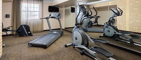 A hotel fitness room with treadmills, elliptical machines, and a stationary bike.