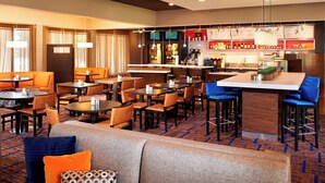 A hotel lobby with seating areas, a bar, and a television screen. - Courtyard by Marriott Rockford (Rockford)