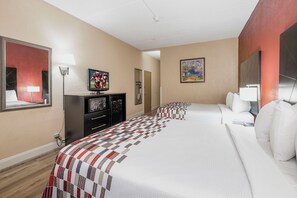 A hotel room with a large bed, a television, a desk, and a mirror. - Red Roof Inn & Suites Macon (Macon)