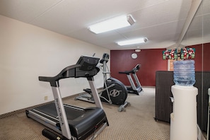 A fitness room with treadmills, a stationary bike, and a water dispenser. - Red Roof Inn & Suites Macon (Macon)