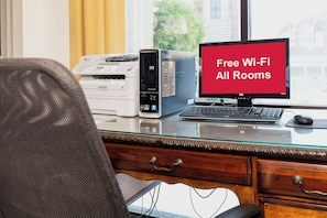 A workspace with a desktop computer, a printer, and a laptop on a glass desk. - Red Roof Inn & Suites Macon (Macon)