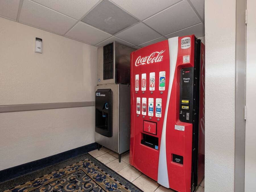 Ein Getränkeautomat mit Coca-Cola-Logo, einem Wasserspender und einem 'Vielen Dank!'-Schild.