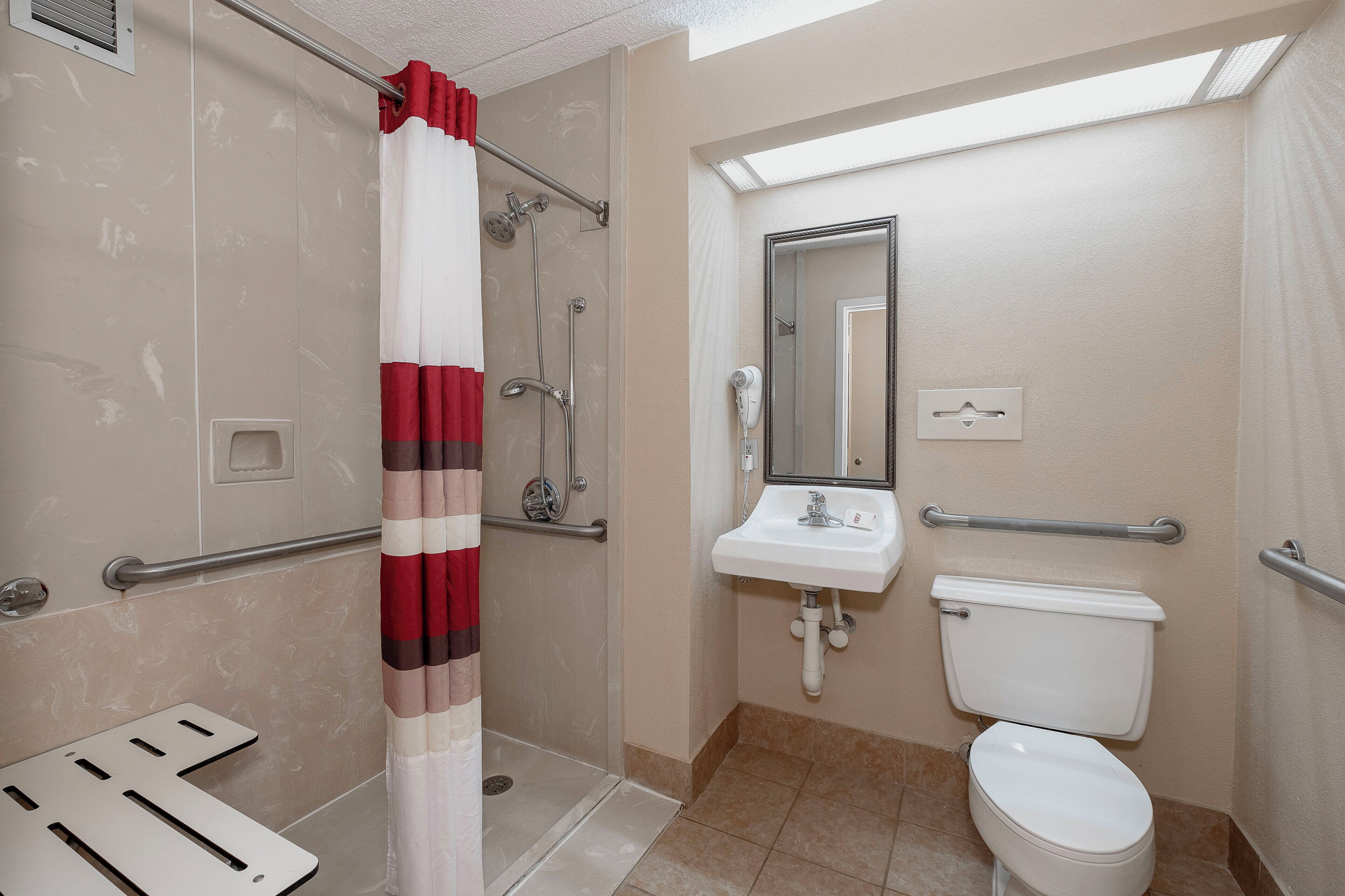 A bathroom with a shower, a sink, and a toilet.