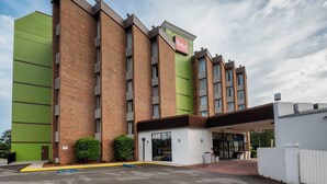 A Red Roof Inn with a brick facade, large windows, and a green accent wall. - Red Roof Inn & Suites Macon (Macon)