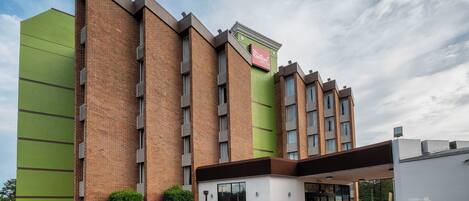 A Red Roof Inn with a brick facade, large windows, and a green accent wall.