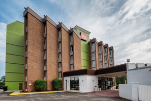 A Red Roof Inn with a brick facade, large windows, and a green accent wall. - Red Roof Inn & Suites Macon (Macon)