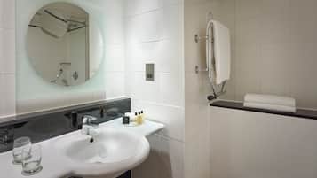 A bathroom with a white sink, mirror, and shower.