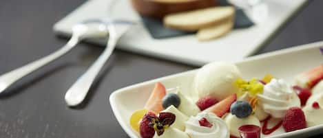 A dessert plate with ice cream, fruits, and whipped cream.