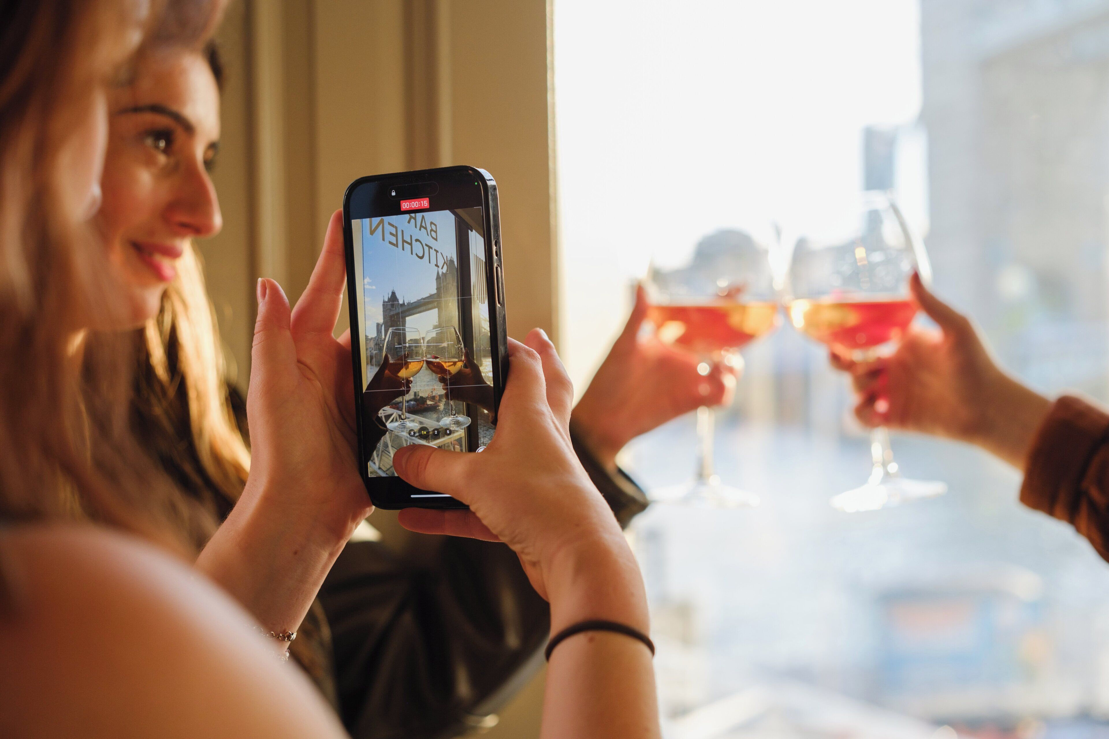 Una persona sosteniendo un teléfono inteligente con vista a un bar.
