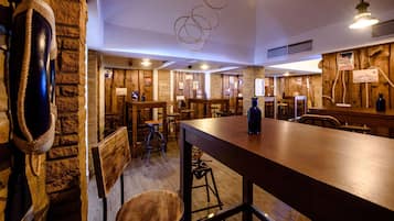 Um interior rústico com mesas e cadeiras de madeira, um balcão de bar comprido e um saco de pancadas pendurado.