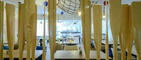 Un restaurant avec des cloisons en bois, des chaises et des tables en osier.