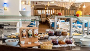 A buffet area with various food items and condiments. - Dorint Hotel Alzey/Worms (Alzey)
