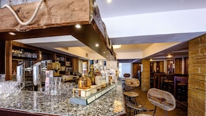 A bar area with a granite countertop, bar stools, and a wooden ceiling. - Dorint Hotel Alzey/Worms (Alzey)