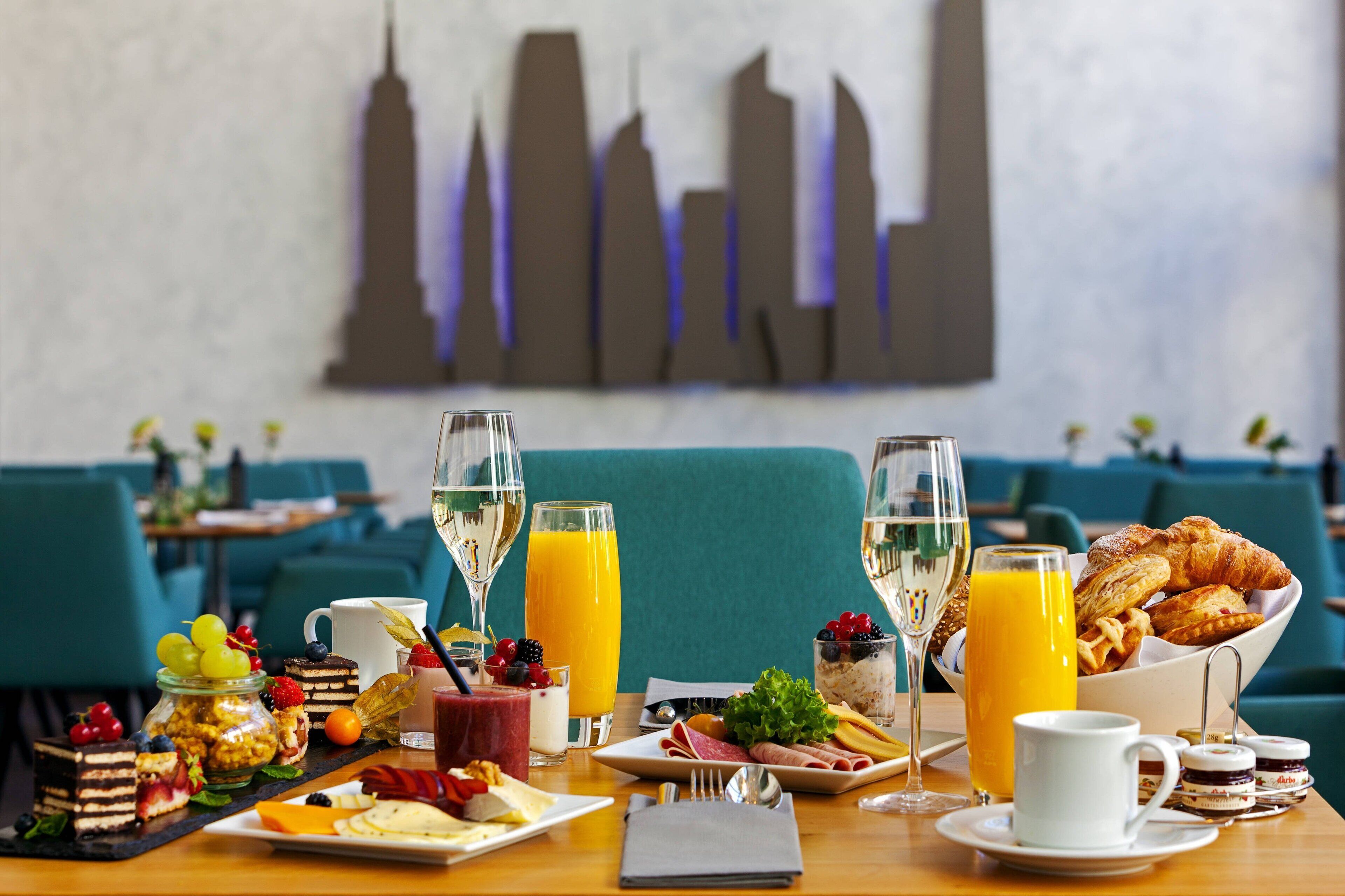 A breakfast buffet with various foods, drinks, and a cityscape view.