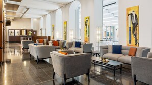 A modern lobby with grey sofas, a coffee table, and artwork on the walls.