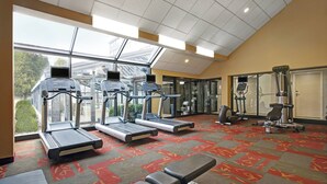 A gym with treadmills, a bench press, and a weight machine. - Courtyard Chicago Elmhurst/Oakbrook Area (Elmhurst)
