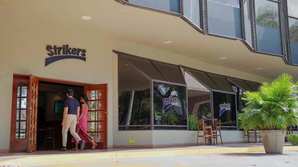 A building with a sign reading "Strikers Sports Bar" and a large potted plant outside. - Barceló Guatemala City (Guatemala City)