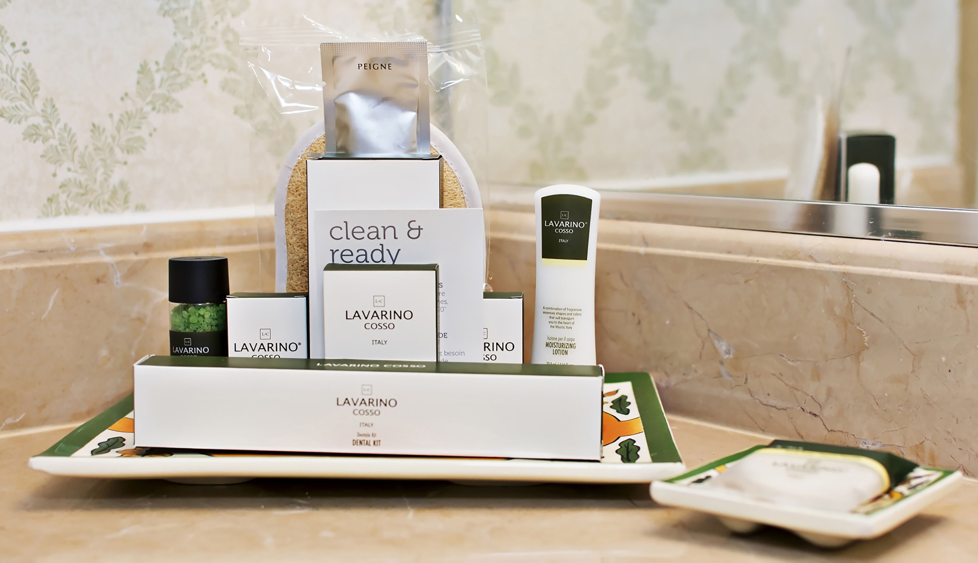 A bathroom counter with a LAVARINO COSSO dental kit, a bottle of RINO so, and a clear plastic bag containing a product.