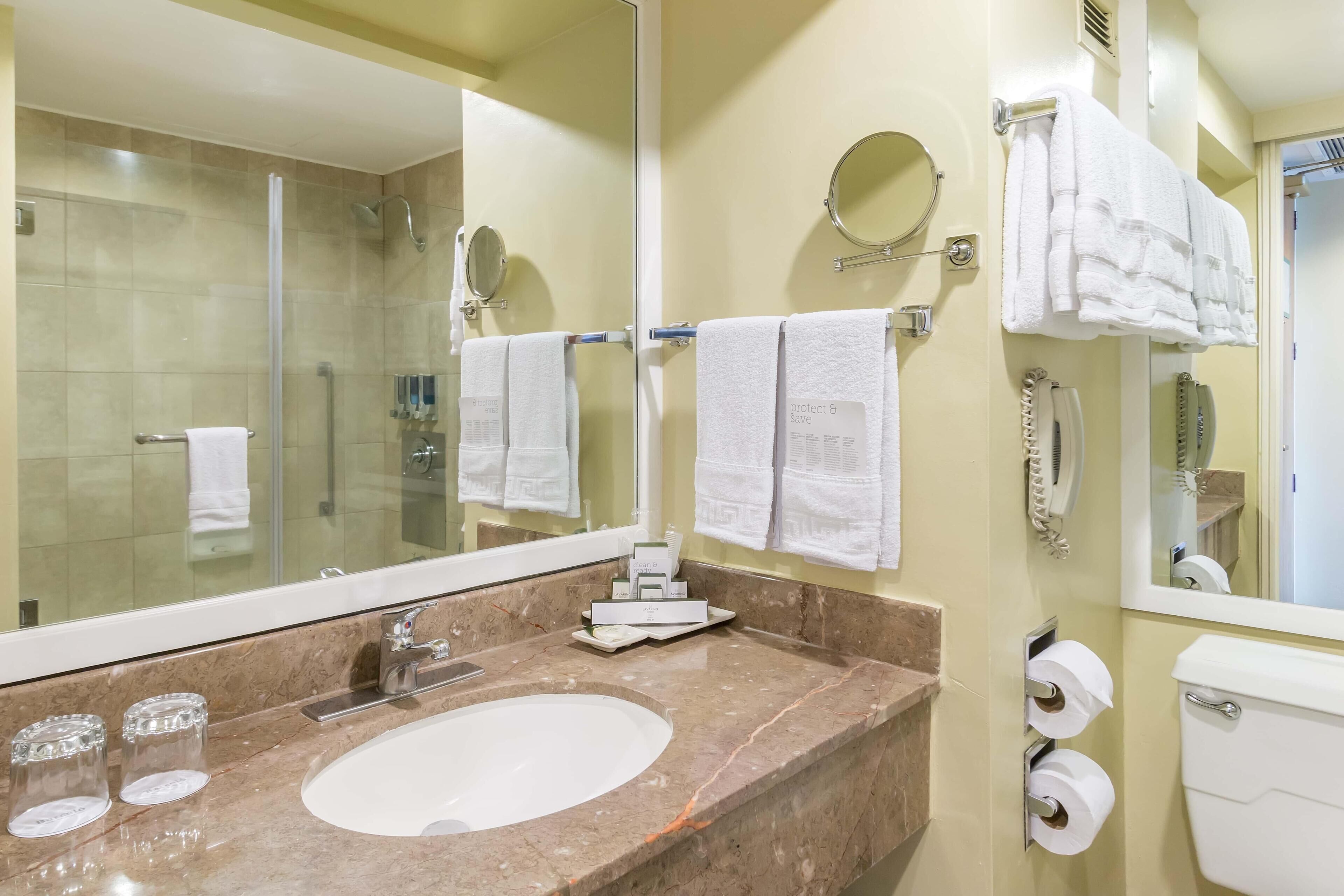 A bathroom with a sink, mirror, towel rack, and toilet.