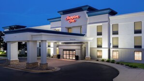 A Hampton Inn hotel with a clear entrance, a covered waiting area, and a sign indicating a 1900 clearance height. - Hampton Inn Dubuque (Dubuque)
