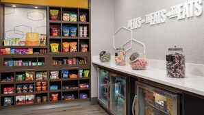 A snack display with various chips and candies, a beverage refrigerator, and a sign reading 'BEVERAGE-AIR'. - Hampton Inn Dubuque (Dubuque)
