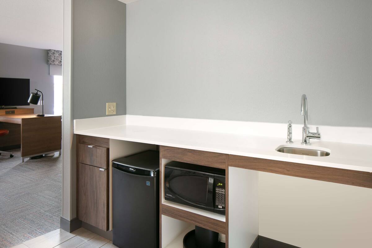 A modern kitchen with a built-in microwave, a sink, and a dishwasher.